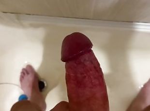The guy quickly jerked off his big uncut dick in the bathroom and cummed on the wall