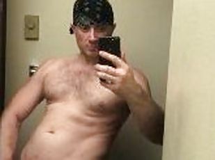 Cute muscular guy strokes cock in mirror