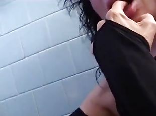 Brunette milf sucking a guy in the bathroom